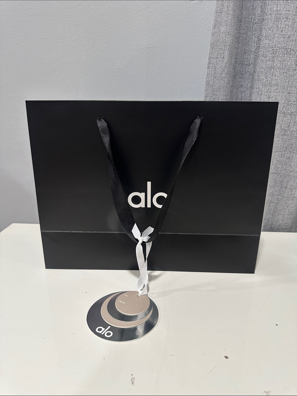 ALO Yoga black medium holiday gift bag with charm.